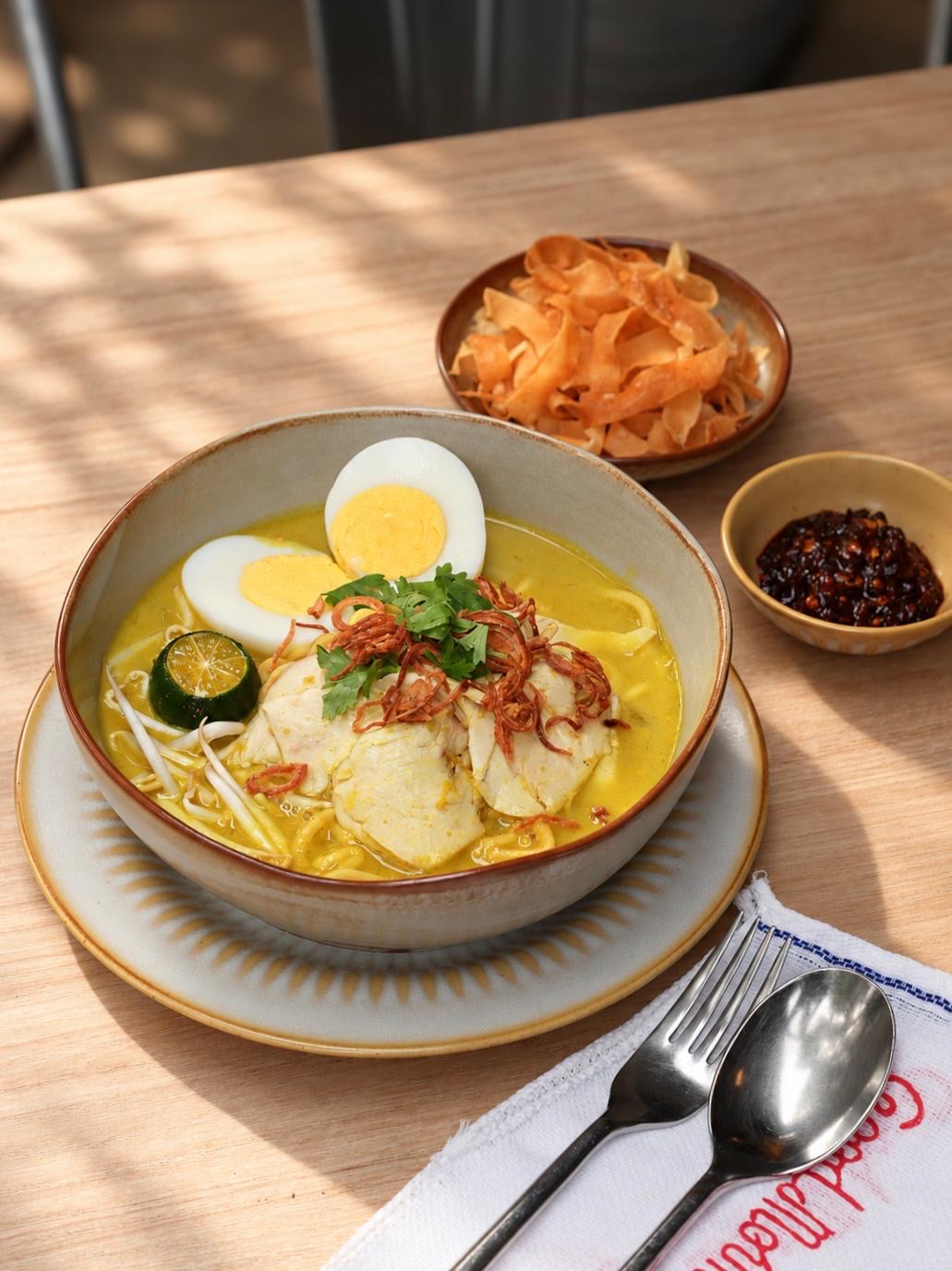 Fortune Food Mee Soto: yellow noodles and bee hoon in golden chicken soup with sliced chicken, egg, bean sprouts, fried shallots, Chinese celery and lime, with popiah skin crackers and chilli